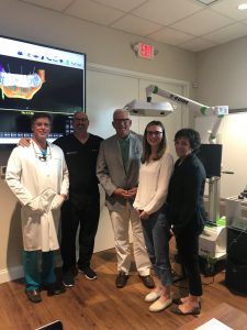 Group photo of the team at Perio Health & Dental Implants in an examination room 